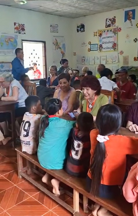 Linda with school children on her travels